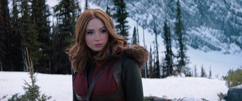 Movie still from “Jumanji: The Next Level” (2019), directed by Jake Kasdan – A woman with red hair wearing a green jacket; Medium shot, Over the shoulder angle
