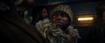 Movie still from “Jumanji: The Next Level” (2019), directed by Jake Kasdan – A person wearing a hat and a fur coat; Close Up shot, Low angle