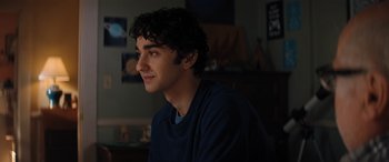 Movie still from “Jumanji: The Next Level” (2019), directed by Jake Kasdan – A young man sitting in front of a window; Close Up shot, Over the shoulder angle