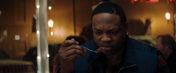 Movie still from “Jumanji: The Next Level” (2019), directed by Jake Kasdan – A person holding a spoon with food in it; Close Up shot, Over the shoulder angle