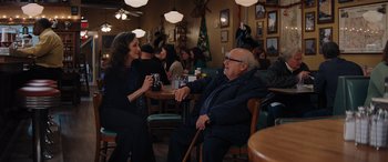 Movie still from “Jumanji: The Next Level” (2019), directed by Jake Kasdan – An older man and a younger woman sitting at a table; Wide shot, Over the shoulder angle