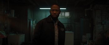 Movie still from “Jumanji: The Next Level” (2019), directed by Jake Kasdan – A man standing in a dark room with a light on; Close Up shot, Low angle