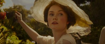 Movie still from “Jungle Cruise” (2021), directed by Jaume Collet-Serra – A beautiful young lady wearing a white hat and holding an umbrella over her head; Close Up shot, Low angle