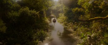 Movie still from “Jungle Cruise” (2021), directed by Jaume Collet-Serra – A boat traveling down a river surrounded by dense vegetation; Extreme Wide shot, High angle