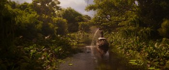 Movie still from “Jungle Cruise” (2021), directed by Jaume Collet-Serra – A boat traveling down a river surrounded by trees; Extreme Wide shot, High angle