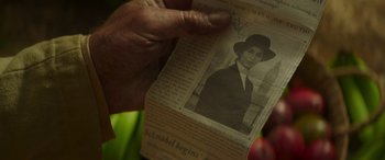 Movie still from “Jungle Cruise” (2021), directed by Jaume Collet-Serra – A person holding up a newspaper with a picture of a woman; Extreme Close Up shot, Over the shoulder angle