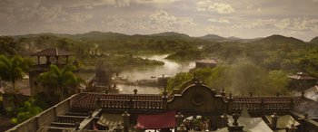 Movie still from “Jungle Cruise” (2021), directed by Jaume Collet-Serra – A view of a lake from a roof of a building; Extreme Wide shot, High angle