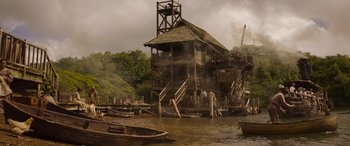 Movie still from “Jungle Cruise” (2021), directed by Jaume Collet-Serra – An old wooden house in the middle of a river; Extreme Wide shot, Low angle