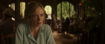 Movie still from “Jungle Cruise” (2021), directed by Jaume Collet-Serra – A woman sitting in front of a table in a room; Close Up shot, Over the shoulder angle