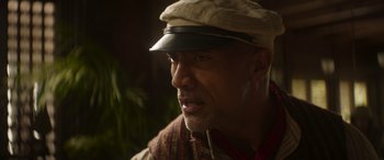 Movie still from “Jungle Cruise” (2021), directed by Jaume Collet-Serra – A person wearing a hat; Close Up shot, Over the shoulder angle