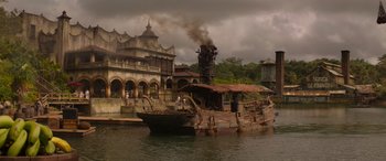 Movie still from “Jungle Cruise” (2021), directed by Jaume Collet-Serra – An old boat is docked in the middle of the water; Extreme Wide shot, Low angle