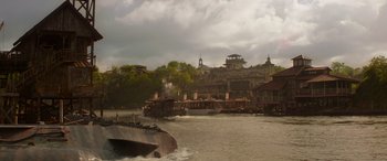Movie still from “Jungle Cruise” (2021), directed by Jaume Collet-Serra – A boat in the water near a building; Extreme Wide shot, Low angle