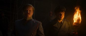 Movie still from “Jungle Cruise” (2021), directed by Jaume Collet-Serra – Two men in military garb standing next to each other in the dark; Close Up shot, Low angle