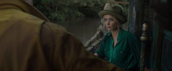 Movie still from “Jungle Cruise” (2021), directed by Jaume Collet-Serra – A woman wearing a green shirt and a green hat; Close Up shot, Over the shoulder angle
