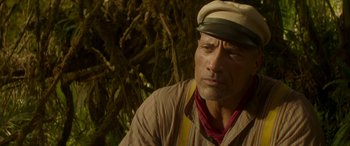 Movie still from “Jungle Cruise” (2021), directed by Jaume Collet-Serra – A person wearing a hat near a tree; Close Up shot, Low angle