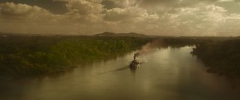 Movie still from “Jungle Cruise” (2021), directed by Jaume Collet-Serra – A person on a raft in a body of water; Extreme Wide shot, High angle