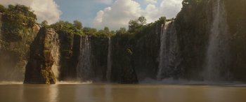 Movie still from “Jungle Cruise” (2021), directed by Jaume Collet-Serra – A large body of water surrounded by a waterfall; Extreme Wide shot, Low angle