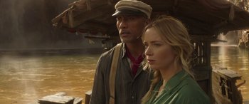 Movie still from “Jungle Cruise” (2021), directed by Jaume Collet-Serra – A man and a woman standing next to each other in front of a body of water; Close Up shot, Over the shoulder angle