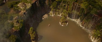 Movie still from “Jungle Cruise” (2021), directed by Jaume Collet-Serra – An aerial view of a body of water surrounded by rocks; Extreme Wide shot, Overhead angle