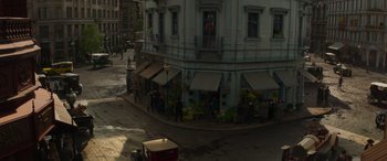 Movie still from “Jungle Cruise” (2021), directed by Jaume Collet-Serra – An aerial view of a street corner with people walking around it; Extreme Wide shot, High angle