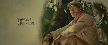 Movie still from “Jungle Cruise” (2021), directed by Jaume Collet-Serra – A painting of a man in a hat sitting in front of a tree; Extreme Close Up shot, Low angle