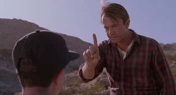 Movie still from “Jurassic Park” (1993), directed by Steven Spielberg – A man pointing at another man in a field; Close Up shot, Over the shoulder angle