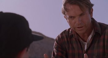 Movie still from “Jurassic Park” (1993), directed by Steven Spielberg – A man talking to another man while standing on a hill; Close Up shot, Over the shoulder angle