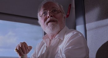 Movie still from “Jurassic Park” (1993), directed by Steven Spielberg – An older man with a beard and glasses; Close Up shot, Low angle