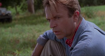 Movie still from “Jurassic Park” (1993), directed by Steven Spielberg – A person sitting on the ground; Close Up shot, Low angle