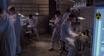 Movie still from “Jurassic Park” (1993), directed by Steven Spielberg – A group of men in white lab coats working in a lab; Wide shot, Low angle