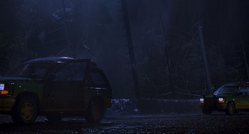 Movie still from “Jurassic Park” (1993), directed by Steven Spielberg – A car is parked in the dark in the woods; Extreme Wide shot, Low angle