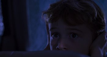 Movie still from “Jurassic Park” (1993), directed by Steven Spielberg – A young child looking at the camera in the dark; Close Up shot, Low angle