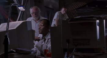 Movie still from “Jurassic Park” (1993), directed by Steven Spielberg – A group of men working on computers in a room; Medium shot, Low angle