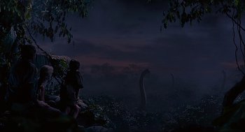 Movie still from “Jurassic Park” (1993), directed by Steven Spielberg – An image of a dinosaur in a field at night time; Extreme Wide shot, Low angle