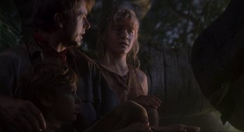 Movie still from “Jurassic Park” (1993), directed by Steven Spielberg – A group of people sitting next to each other in the dark; Medium shot, Low angle