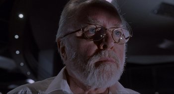 Movie still from “Jurassic Park” (1993), directed by Steven Spielberg – An old man with a beard wearing glasses; Close Up shot, Low angle
