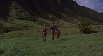 Movie still from “Jurassic Park” (1993), directed by Steven Spielberg – A man and two children standing in a grassy field; Extreme Wide shot, Low angle