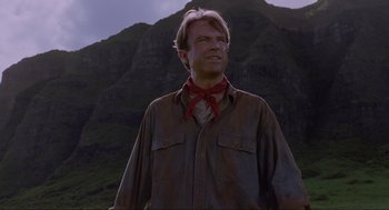 Movie still from “Jurassic Park” (1993), directed by Steven Spielberg – A man standing in front of a mountain with his eyes closed; Close Up shot, Low angle