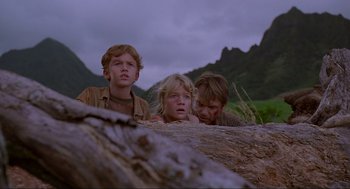 Movie still from “Jurassic Park” (1993), directed by Steven Spielberg – Three children are standing next to each other in a field; Medium shot, Low angle