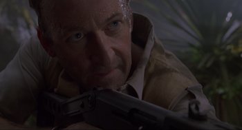 Movie still from “Jurassic Park” (1993), directed by Steven Spielberg – A person holding a gun; Close Up shot, Low angle