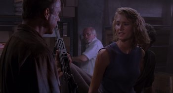 Movie still from “Jurassic Park” (1993), directed by Steven Spielberg – A man and a woman holding a gun in a room; Medium shot, Over the shoulder angle