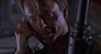 Movie still from “Jurassic Park” (1993), directed by Steven Spielberg – A person holding a phone to his ear; Close Up shot, Low angle
