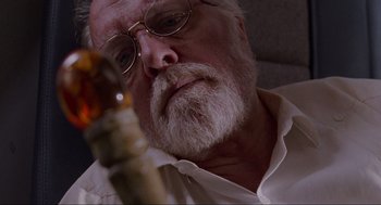 Movie still from “Jurassic Park” (1993), directed by Steven Spielberg – An older man with a beard and glasses looking at the camera; Close Up shot, Low angle