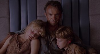 Movie still from “Jurassic Park” (1993), directed by Steven Spielberg – A man and two children sitting next to each other; Close Up shot, High angle