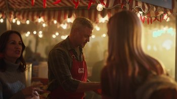 Movie still from “Euphoria” (2019), created by Sam Levinson – A man wearing an apron is serving a woman at an outdoor event; Medium shot, Over the shoulder angle