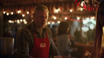 Movie still from “Euphoria” (2019), created by Sam Levinson – A man wearing an apron standing in front of lights; Medium shot, Low angle