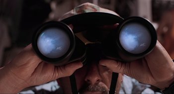 Movie still from “Jurassic Park III” (2001), directed by Joe Johnston – A man looking through a pair of binoculars; Extreme Close Up shot, Overhead angle