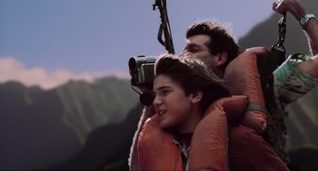 Movie still from “Jurassic Park III” (2001), directed by Joe Johnston – A man and a boy in life jackets holding a camera; Medium shot, Low angle
