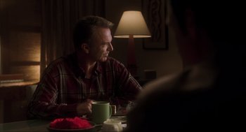 Movie still from “Jurassic Park III” (2001), directed by Joe Johnston – A man sitting at a table with a cup of coffee; Medium shot, Over the shoulder angle