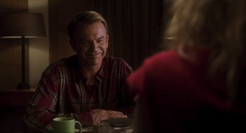 Movie still from “Jurassic Park III” (2001), directed by Joe Johnston – A man sitting at a table with a cup of coffee; Medium shot, Over the shoulder angle